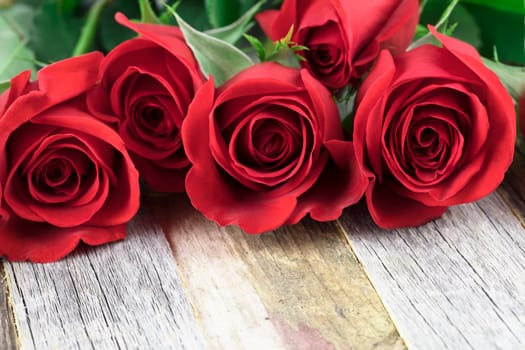 Romantic red roses for a special occasions on a wooden background with copy space.