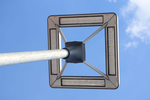 A street lamp with a blue sky in the background.