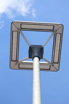 A street lamp with a blue sky in the background.