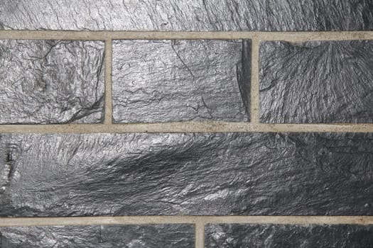 A wall cladding made of grey slate slabs.