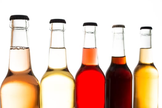 Colorful lemonades in bottles in backlight