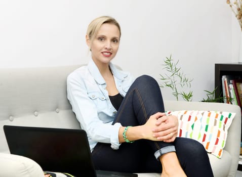 portrait of beautiful young blonde woman sitting on the sofa
