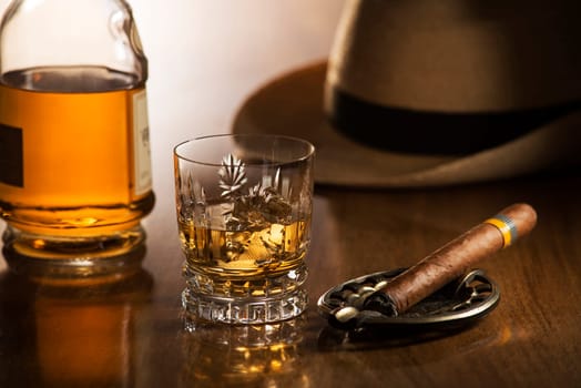 Whiskey and cigar on wooden background close up