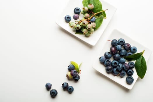 Fresh blueberries with green leaves on wooden background