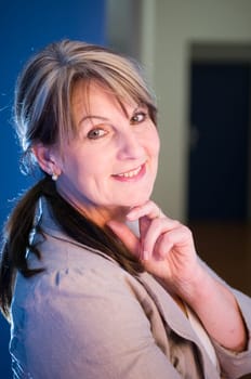 Side upper body portrait of a middle-aged woman in a blue vesthalle.
