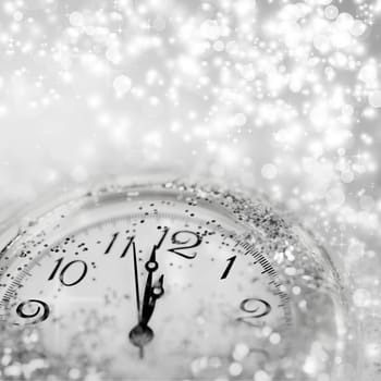 Background of holiday lights and clock close to midnight