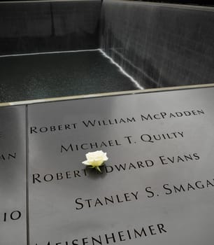 NEW YORK - APRIL 27, 2016: Names panels with a white rose at the 9/11 Memorial site in Manhattan