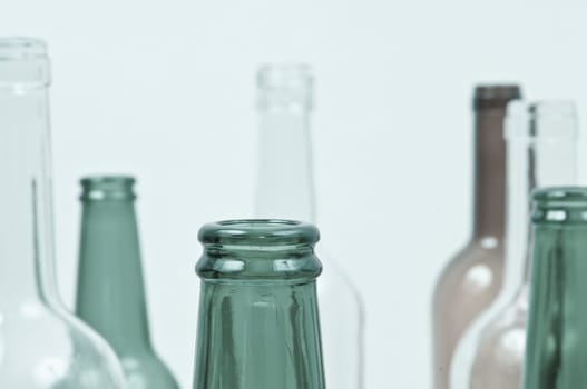 Empty glass bottles of mixed colors including green, clear white, brown