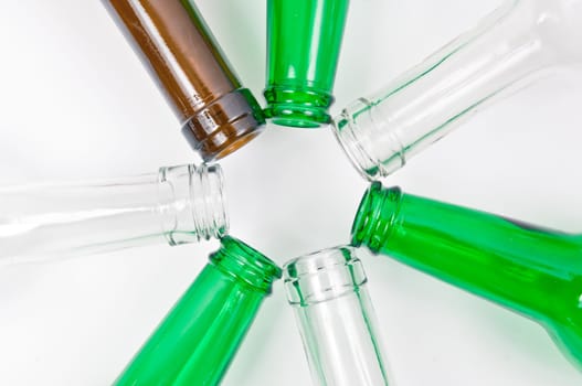 Empty glass bottles of mixed colors including green, clear white, brown
