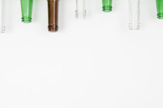 Empty glass bottles of mixed colors including green, clear white, brown
