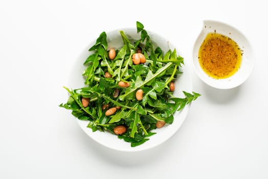 Fresh dandelion salad with beans on white background