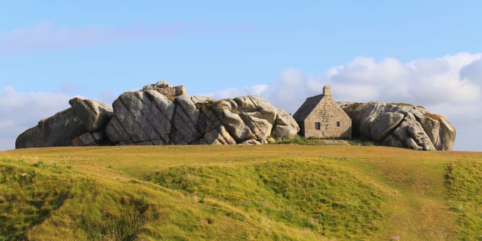 Little house inside the rocks in Meneham village, Kerlouan, Brittany, France