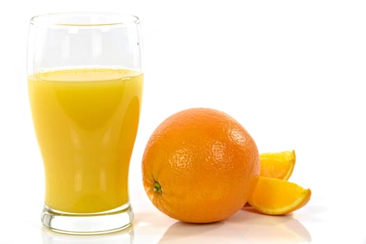 Glass of natural orange juice and pieces of orange isolated on a white background