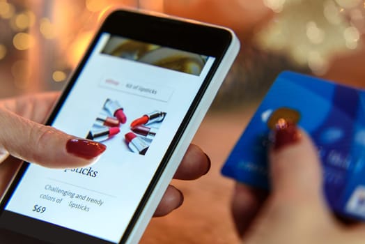 Modern Woman makes shopping via smartphone and a credit card in the e-store