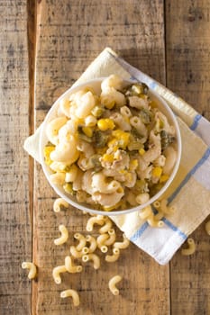 Close up of a salad with pasta, yellow corn and Italian seasonings.