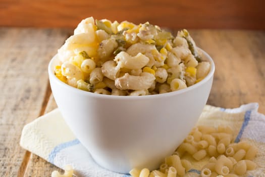 Close up of a salad with pasta, yellow corn and Italian seasonings.