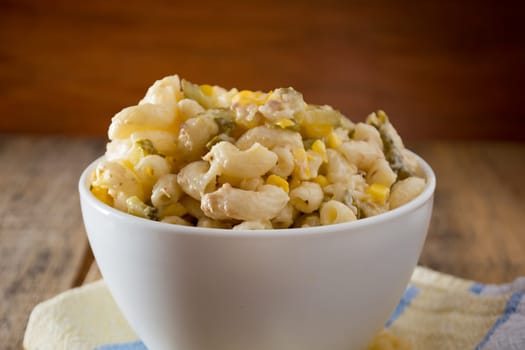 Close up of a salad with pasta, yellow corn and Italian seasonings.