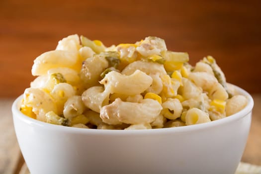 Close up of a salad with pasta, yellow corn and Italian seasonings.