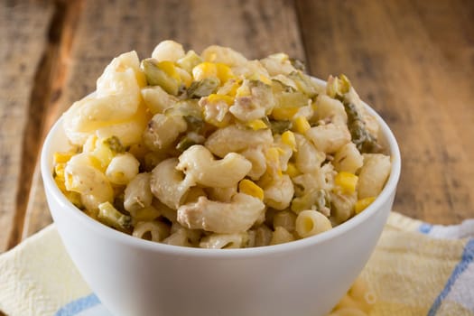 Close up of a salad with pasta, yellow corn and Italian seasonings.
