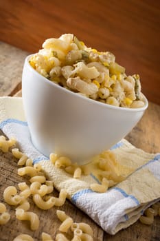 Close up of a salad with pasta, yellow corn and Italian seasonings.