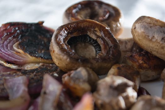 Roasted mushrooms with onion on white plate