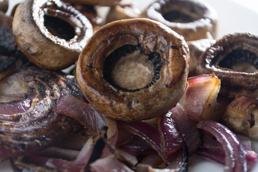 Roasted mushrooms with onion on white plate