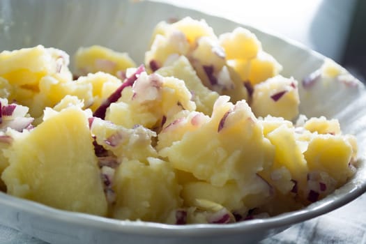 Potato salad with onions  (Selective Focus, Focus one third into the bowl)