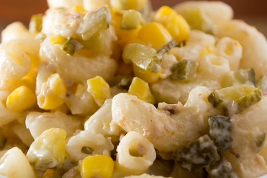 Close up of a salad with pasta, yellow corn and Italian seasonings.