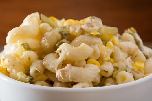 Close up of a salad with pasta, yellow corn and Italian seasonings.