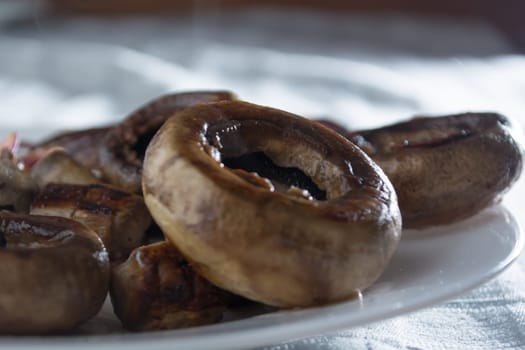 Roasted mushrooms with onion on white plate