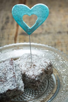 Close up of chocolate cakes with coconut flour on the glass plate with blue ornaments