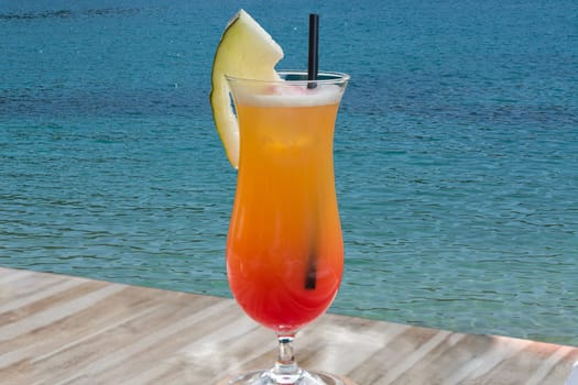 Colorful cocktail on the table of a bar in the restaurant in the background the blue sea..