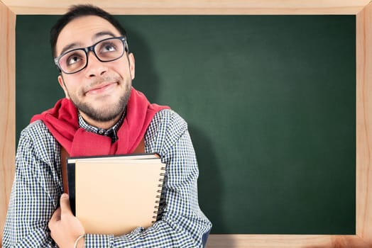 Nerd student posing with books against a chalk board