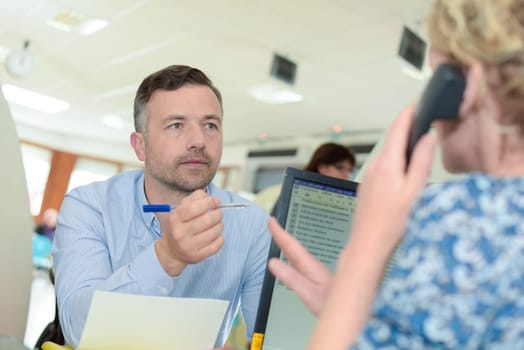 shot of a young businessman talking with female colleague