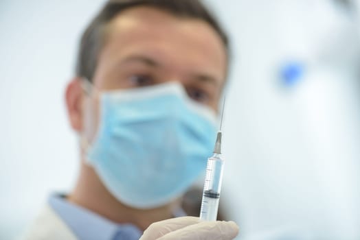 doctor in medical mask ready to make injection