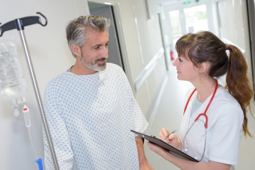 female doctor interacting with patient in hospital corridor