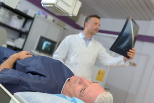 doctor checking xray of a senior patient in hospital