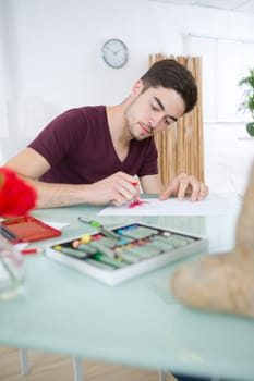 young man drawing pictures in studio