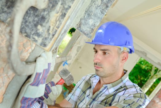 Builder fixing metal tie to wall