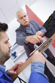 close-up carpenter process of wood door marking for locksmith installation