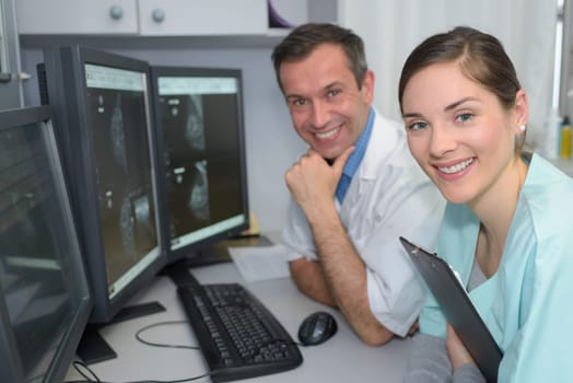 portrait of two doctors smiling in monitoring room in hospital