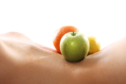 fruit diet,health and beauty. naked woman lying on her back with a located fruit,apple,tangerine,lemon.