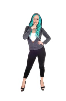 A young tall woman in black tights and high heels standing isolated.for white background with long blue hair and finger over mouth..