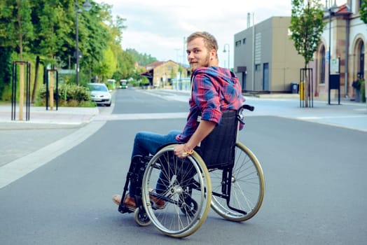 young disabled man in wheelchair on road