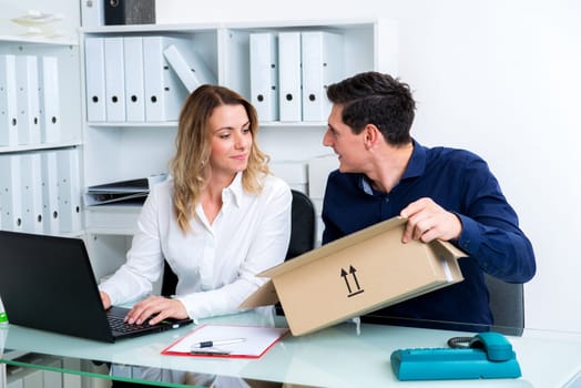 young businessman and businesswoman with delivery in the office