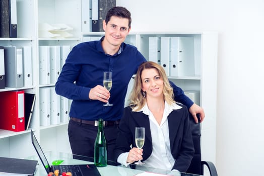 young businessman and businesswoman celebrating together in the office