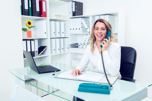 young blond businesswoman calling in the office