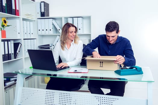 young businessman and businesswoman with delivery in the office
