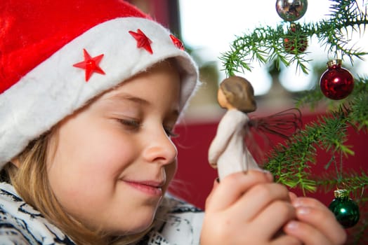 nice girl with Santa- cap and wooden angel