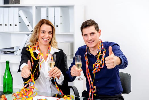 young businessman and businesswoman celebrating together in the office